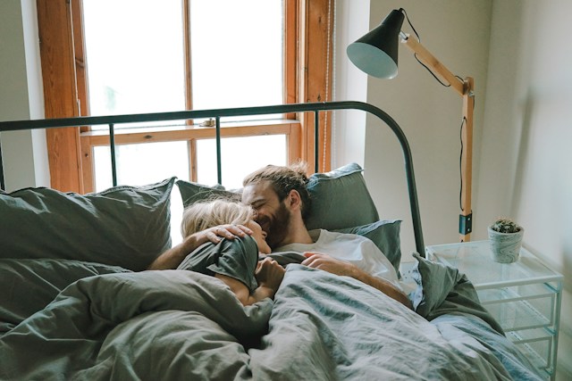 persons sleeping in the bed with metal frame